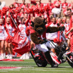 Hoosier Bison rides a motorcycle on the field at Memorial Stadium.