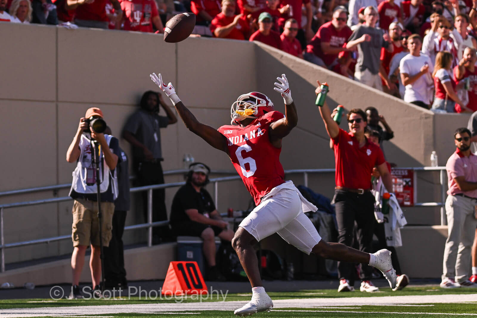 IU football player attempts to catch the ball.